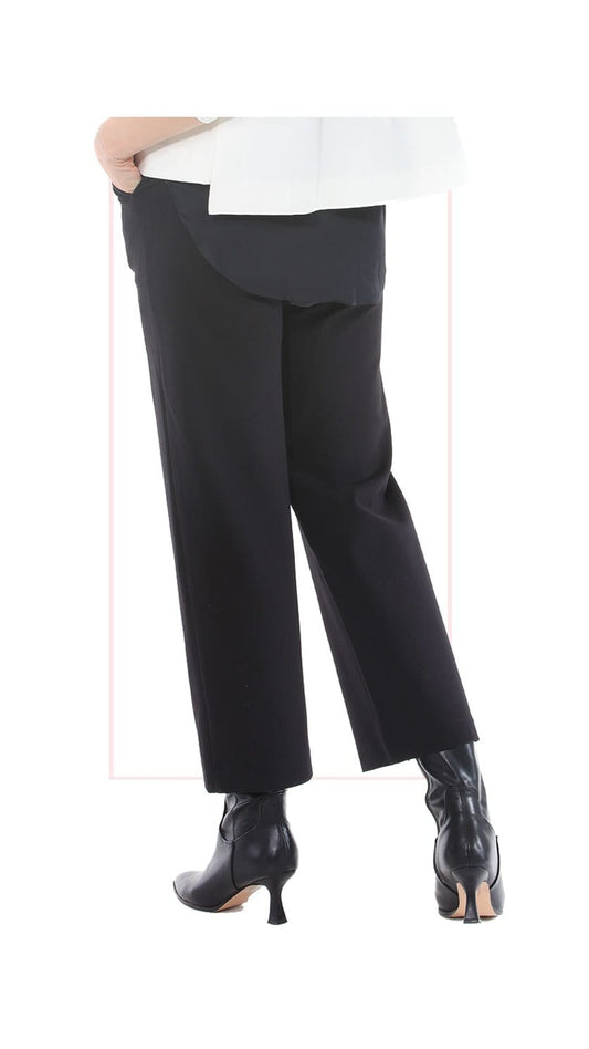 Black wide-leg trousers shown on a model from the back, paired with black heeled ankle boots and a white top, against a plain white background.