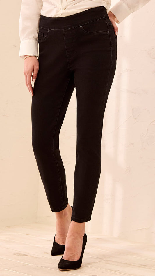 Person wearing black pants and a white top on a beige background