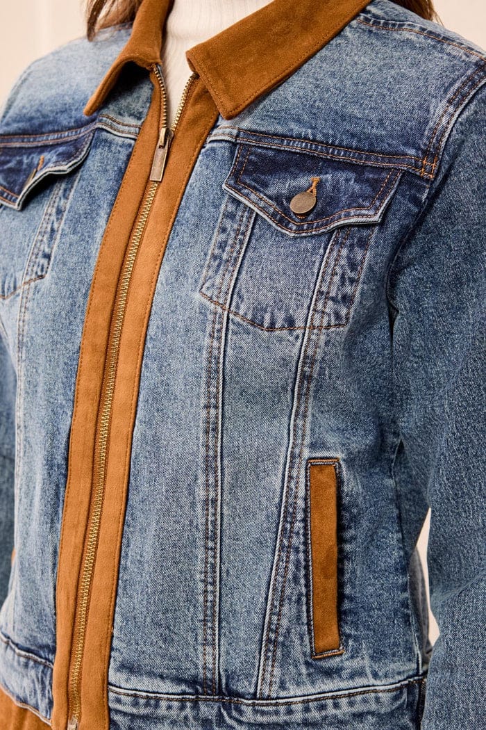 Close-up of a blue denim jacket with tan suede-like trim, collar, zipper placket, and a vertical welt pocket detail.