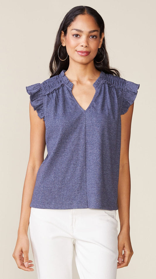 Relaxed, straight style top with notched v-neck with short stand-up collar, smocked detail at the shoulders, relaxed ruffle cap sleeve and center seam detail in front cotton blue