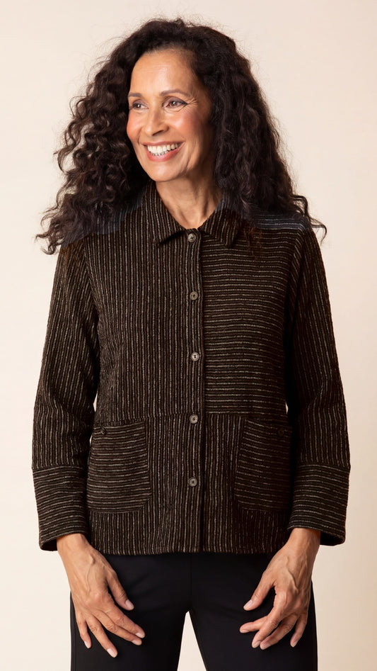 Woman wearing a brown textured jacket against a beige background