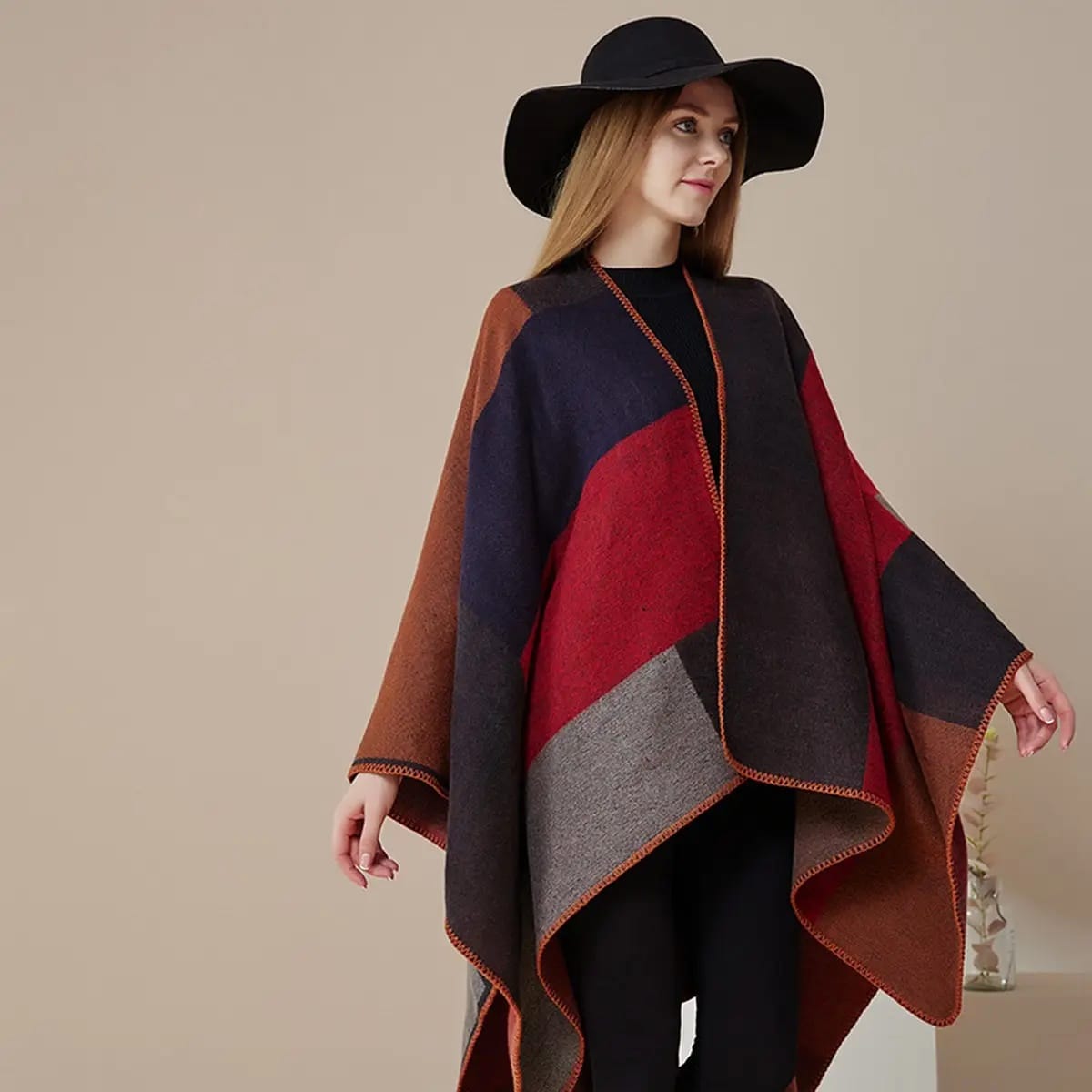 Woman wearing a colorful poncho with a plain background