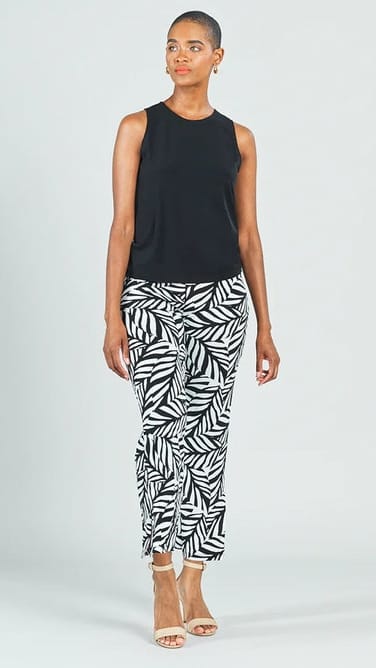 Woman wearing a black sleeveless top and zebra print pants on a white background