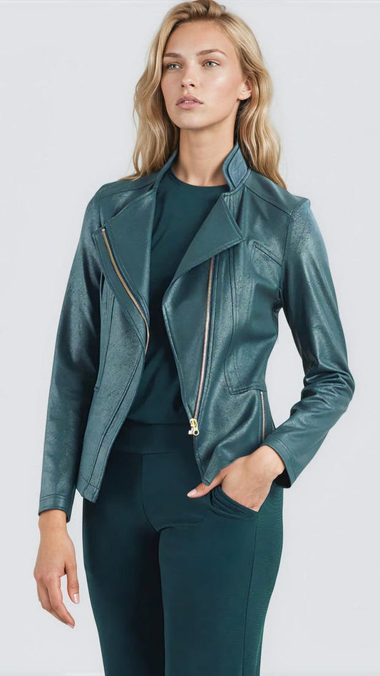 A woman modeling a teal green faux leather moto jacket with gold-tone zippers, worn over a matching dark green top and trousers, against a light gray studio background.