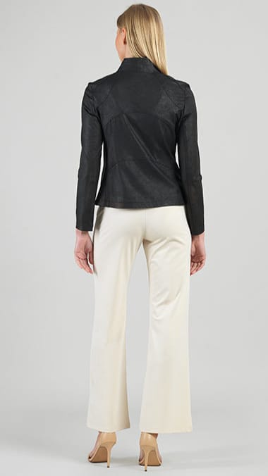 Woman wearing a black leather jacket and white pants on a plain background