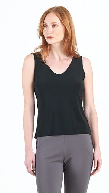 Woman wearing a black sleeveless top and gray pants on a white background