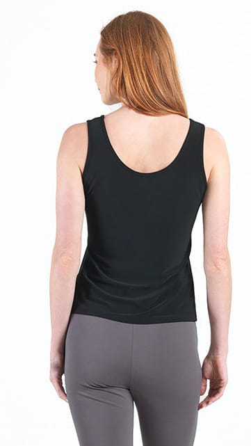 Person wearing a black tank top and gray leggings on a white background