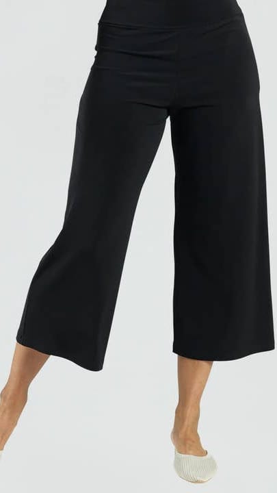 Black wide-leg pants worn by a person on a white background