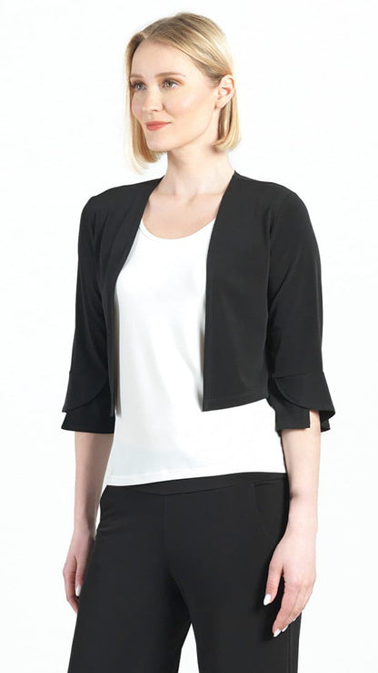 Woman wearing a black cardigan over a white top and black pants on a white background