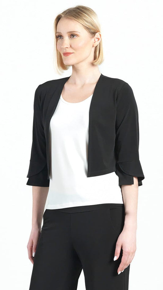 Woman wearing a black cardigan over a white top and black pants on a white background