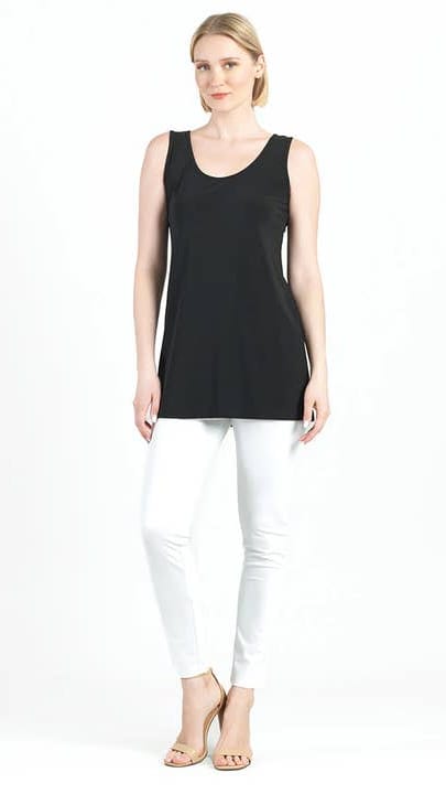 Woman wearing a black sleeveless top and white pants on a white background