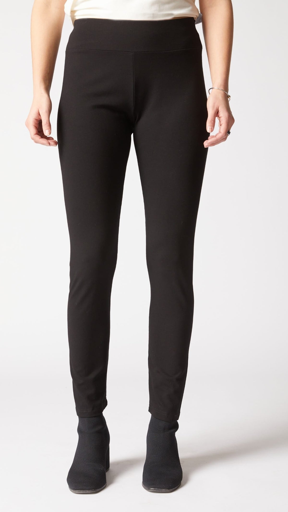 Person wearing black pants on a white background
