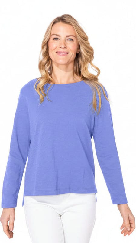 Woman wearing a blue long-sleeve blue top on a white background