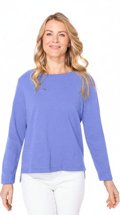 Woman wearing a blue long-sleeve blue top on a white background