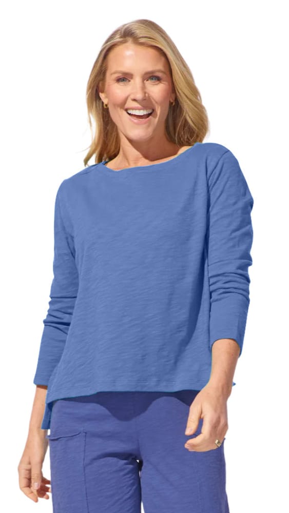 Woman wearing a blue long-sleeve top and pants on a white background