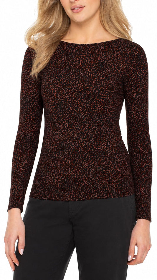 A woman wearing a long-sleeve boat-neck knit top with a dark brown and black textured pattern, paired with black pants, shown against a plain white background.