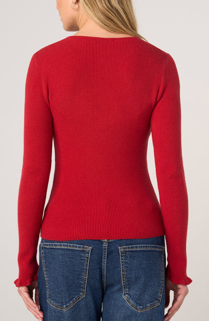 A woman shown from the back wearing a fitted, long-sleeve ribbed knit sweater in a vibrant red color, paired with blue jeans, against a plain light gray studio background.