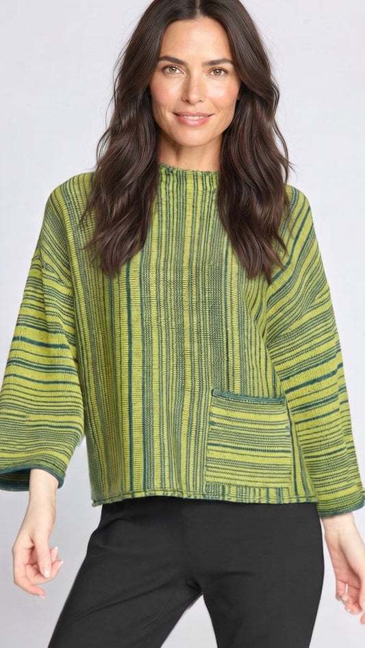 A woman modeling a green and yellow striped textured top with three-quarter sleeves and a front patch pocket, paired with black pants, against a light gray studio background.