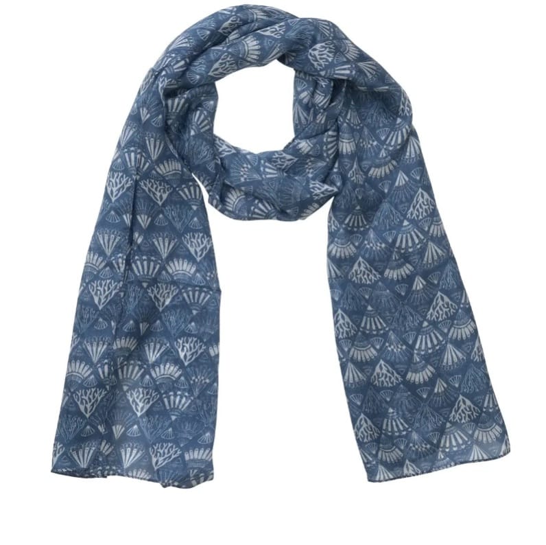 A blue silk scarf with a white geometric and fan-like shell pattern, draped in a loop against a plain white background.