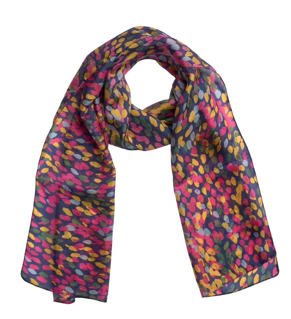 A lightweight silk scarf with a dense, abstract multicolor pattern of pink, yellow, and light blue spots on a dark charcoal gray background, shown against a plain white studio background.