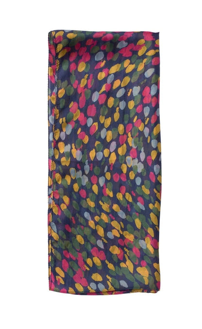 A folded silk scarf featuring a colorful abstract leaf or droplet pattern in pink, yellow, green, and gray on a dark navy blue background, set against a plain white studio backdrop.