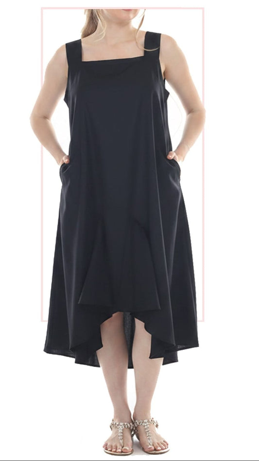 A woman modeling a black sleeveless high-low dress with a square neckline, wide shoulder straps, side pockets, and an asymmetrical draped hem, paired with metallic strappy sandals.