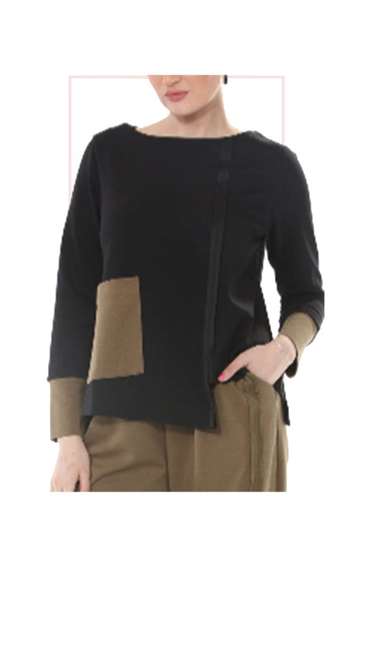 A woman wearing a black long-sleeve top with tan color-block panels on the front and sleeves, paired with tan pants, shown against a plain white background.