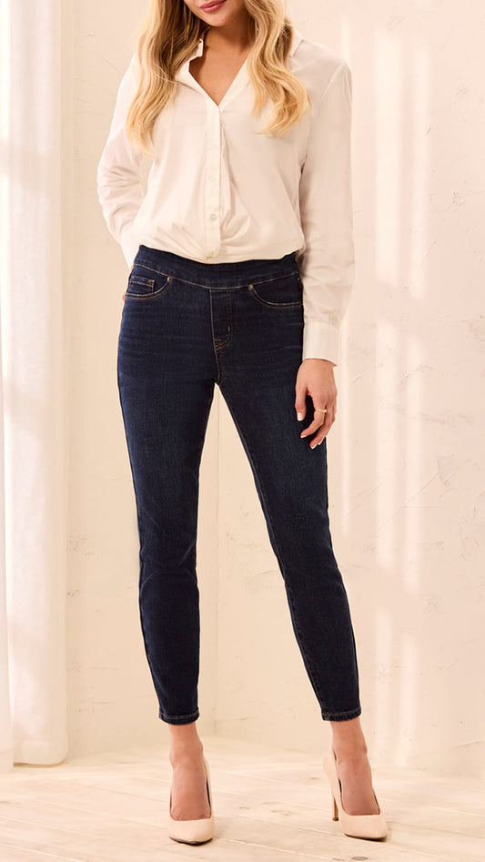 Person wearing a white blouse and dark jeans against a white background