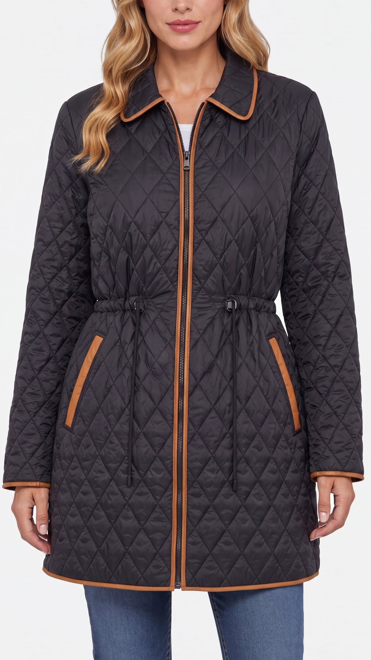 A woman wearing a black diamond-quilted coat with tan contrast trim, a tan drawstring waist, and zippered pockets, shown against a plain light background.