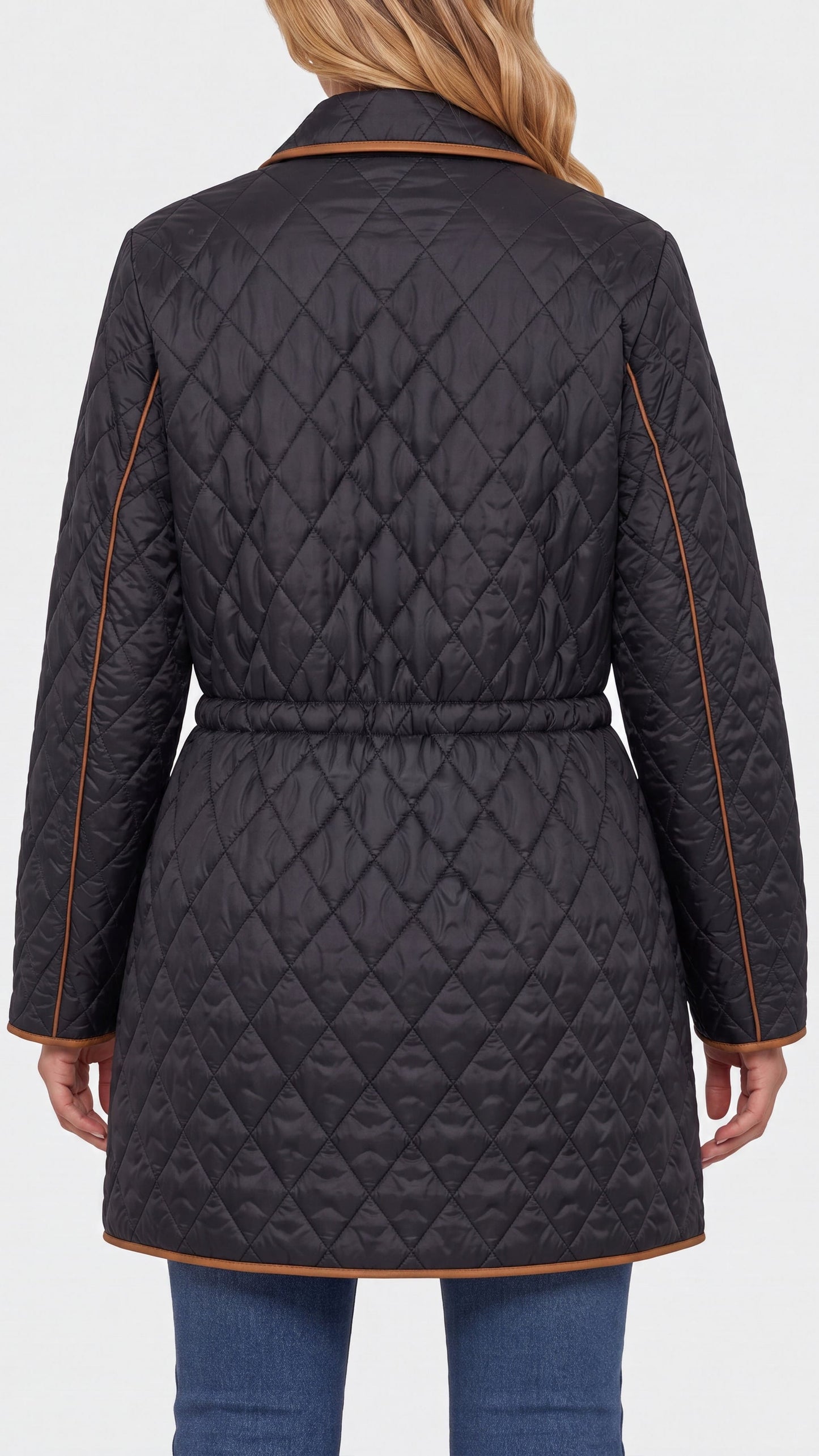A woman shown from the back wearing a dark charcoal gray quilted jacket with tan contrast piping and a tan collar, paired with blue jeans against a light gray studio background.